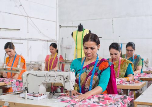 Woman,Textile,Worker,Using,Sewing,Machine,On,Production,Line